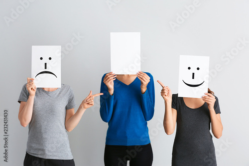 Young women hiding faces be...