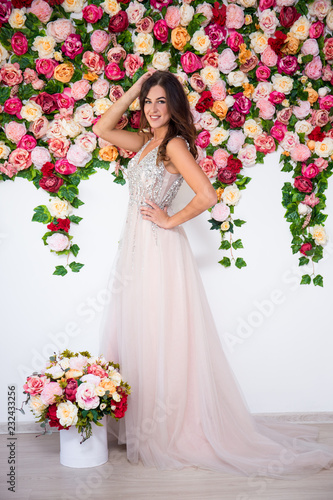 full length portrait of beautiful girl in dress posing over colorful flowers background