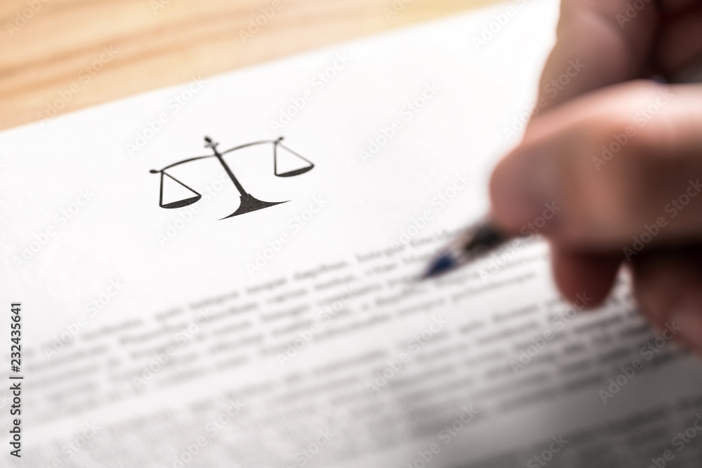 Fototapeta premium Attorney, lawyer, solicitor or jurist working on a business brief in law firm. Legal contract, clause or article paper. Man writing document with scale icon and sign with pen. Judge making decision.