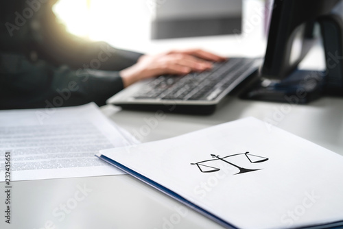 Attorney with computer. Lawyer working in law firm and company. Solicitor or jurist doing paperwork. Professional business woman writing her will or legal document. Paper with scale icon on desk.