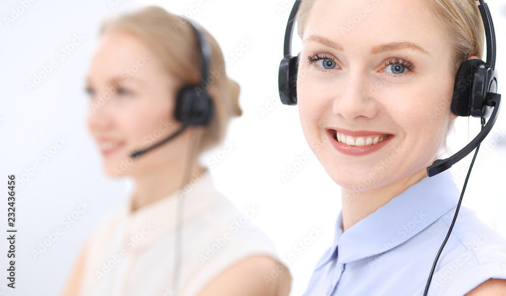 Bright call center office. Two blonde women in a headset Bright call center office. Two blonde women in a headset