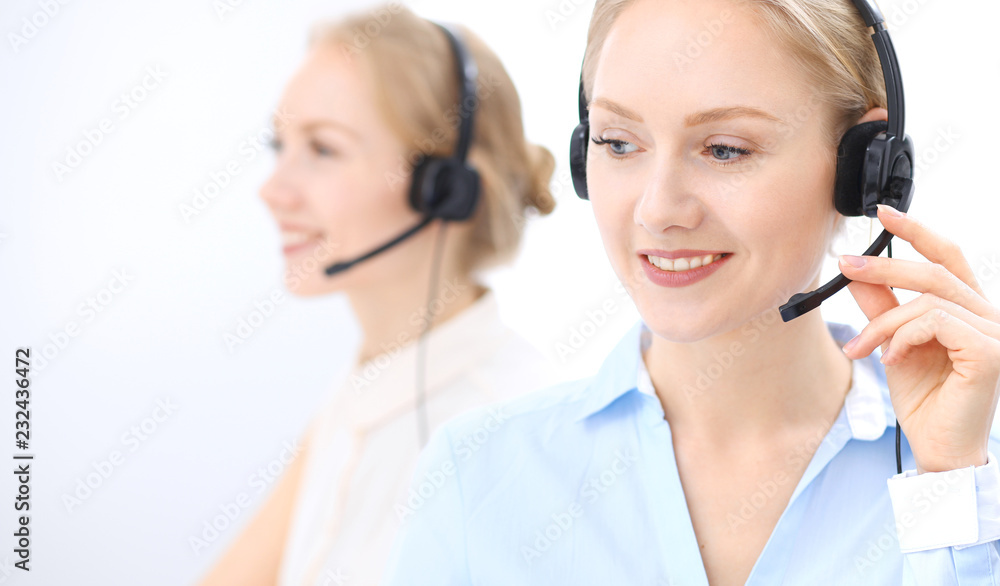 Bright call center office. Two blonde women in a headset Bright call center office. Two blonde women in a headset