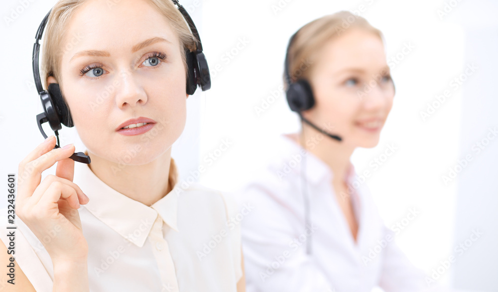 Bright call center office. Two blonde women in a headset Bright call center office. Two blonde women in a headset