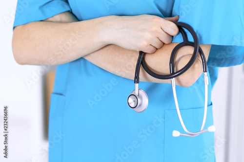 Doctor holding stethoscope with arms crossed, closeup. Medical help and insurance in health care, best treatment and medicine concept