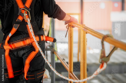 Construction worker wearing safety harness and safety line working high place at industrial.