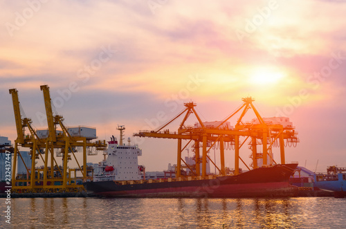 Container Cargo ship and cargo plane with working crane bridge in shipyard during sunrise,logistic import export and use for freight cargo.