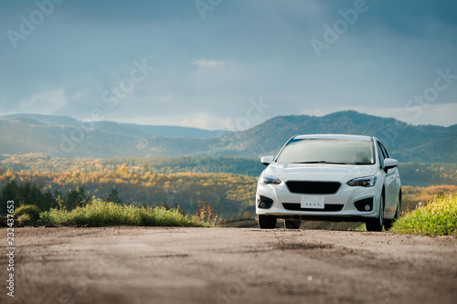 Road Trip Concept, Driving Car in Fall and Autumn Season, Beautiful Foliage and Mountains Hills as background