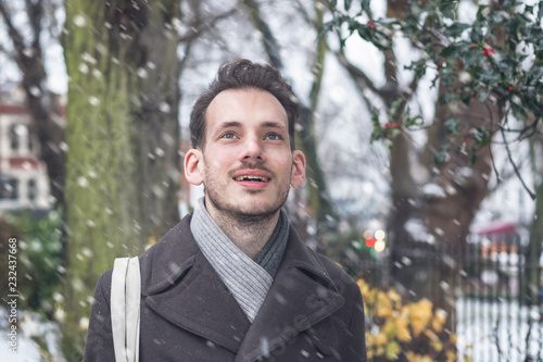 A smiling handsome young man in winter snow