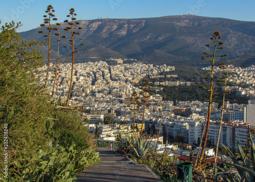 Cityscape of Athens with white buildings architecture, mountain, aloe and blue sky