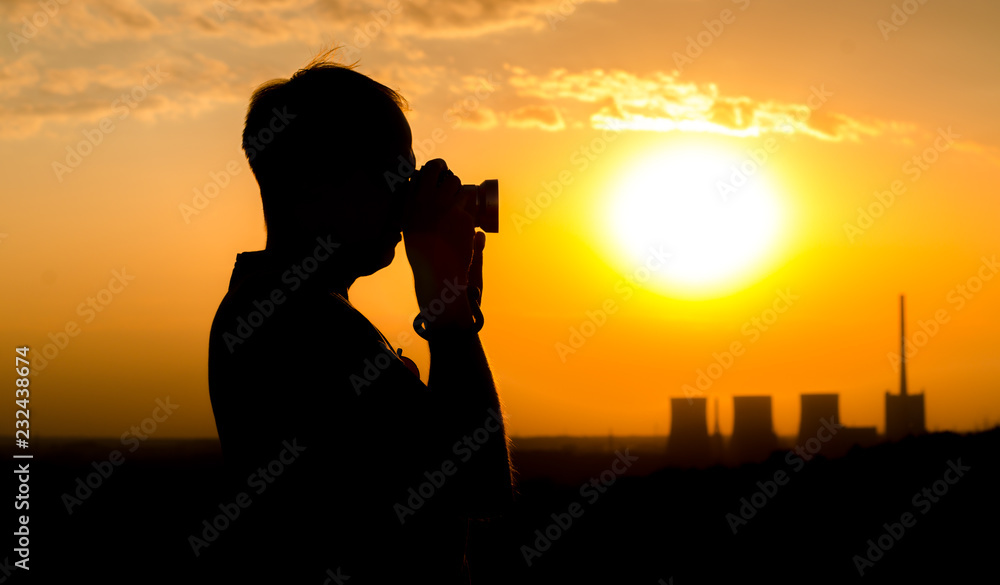 Fotograf im Sonnenuntergang mit Kraftwerk