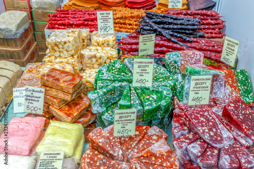 Sale of sweets at the fair. Text in Russian: Istanbul dessert, churchchel, chak-chak, baklava, pishmania and other names of sweets. photo