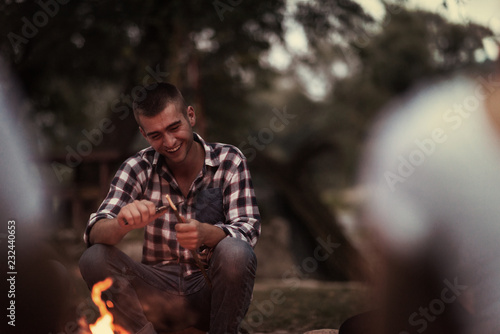 young friends relaxing around campfire © .shock