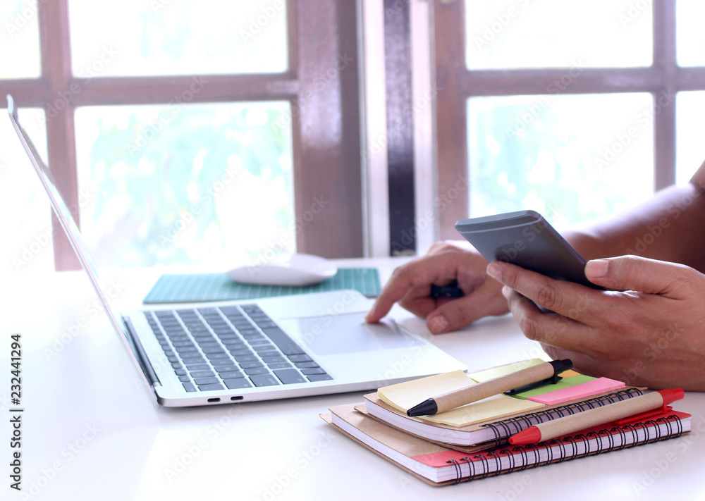 Fototapeta premium side view,business man holding smartphone and point.office table desk. workspace with notebook and mouse on copy space