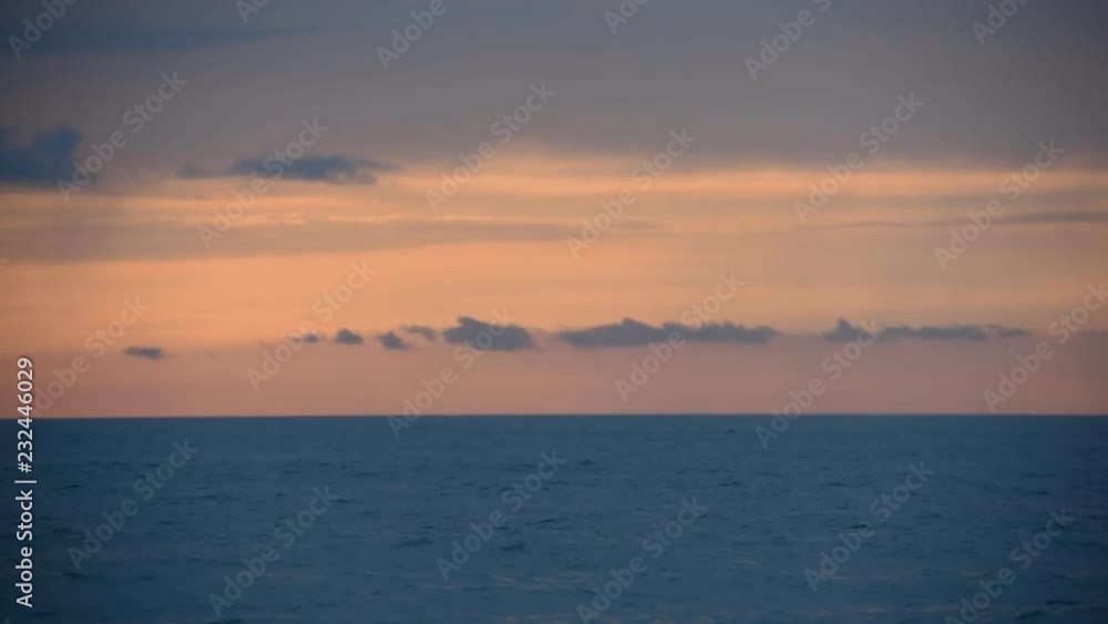 Sunset at sea, shallow depth of field. Dramatic dark blue sea and sky with clouds colored by sunset, view from Batumi main beach (Black Sea), Georgia Sunset at sea, shallow depth of field. Dramatic dark blue sea and sky with clouds colored by sunset, view from Batumi main beach (Black Sea), Georgia