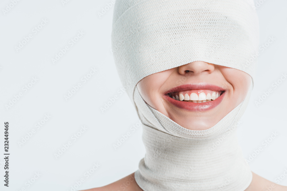 close up of woman face with white bandages and smile isolated on white close up of woman face with white bandages and smile isolated on white