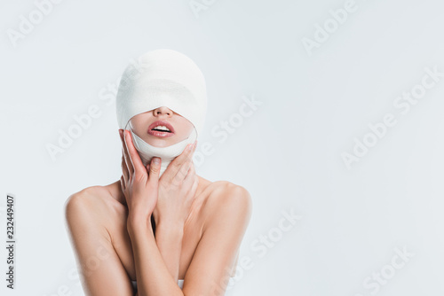 Fotografering naked woman with bandages on head after plastic surgery isolated on white