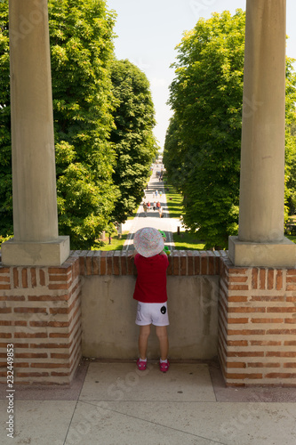 Mogosoaia, Romania - August 05, 2018: young girl looking at the alley entrance at Mogosoaia Palace near Bucharest, Romania. photo