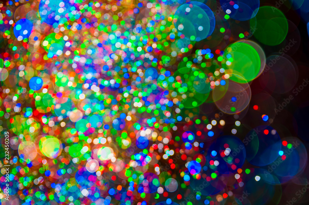 Holiday lights background in abstract bokeh bubbles floating against a dark night sky