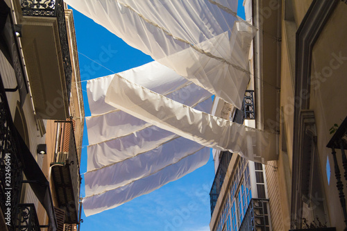Shadow curtains on the street in Seville, Spain protecting tourists from sun and heat.