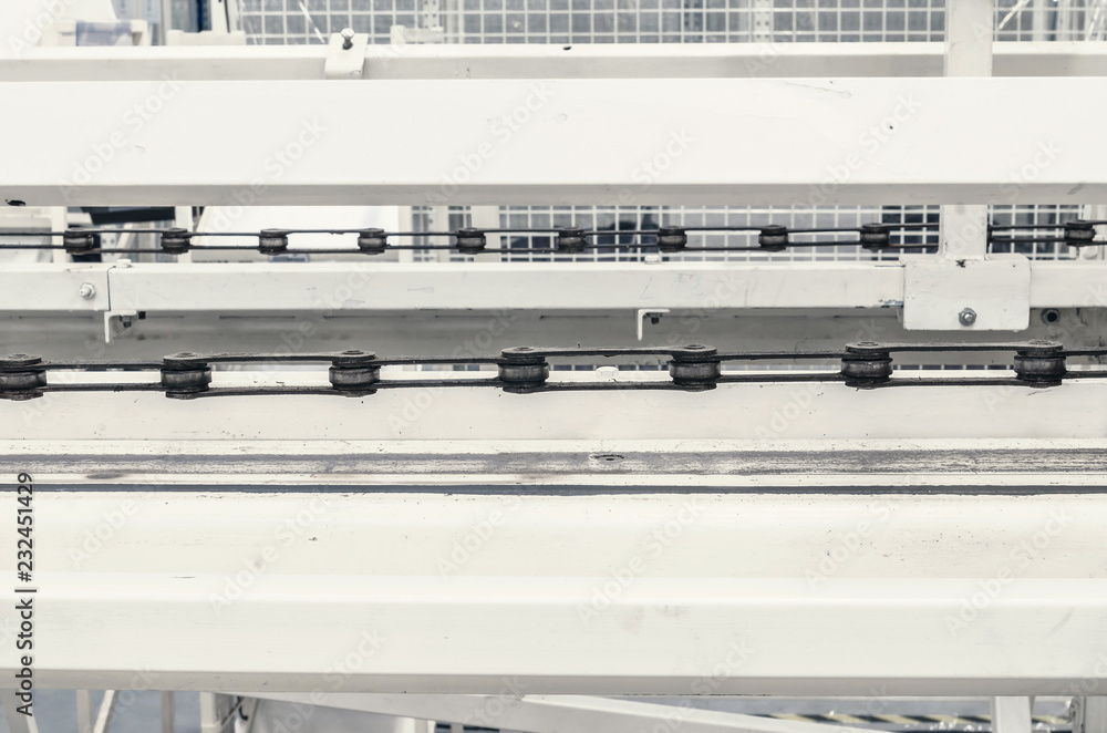 Large conveyor belt on a metal chain at a manufacturing plant Large conveyor belt on a metal chain at a manufacturing plant