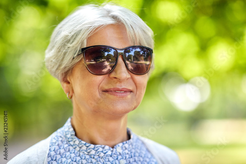 old age, eyewear and people concept - portrait of happy senior woman in sunglasses at summer park