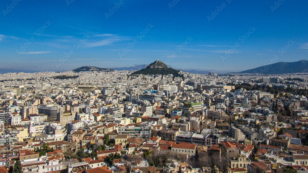 Athens from Acropolis showing Mount Lycabettus with white buildings architecture, mountain, trees, blue sky and floating white cloud background