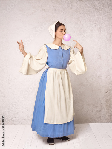 Medieval Woman in Historical Costume Wearing Corset Dress and Bonnet. photo