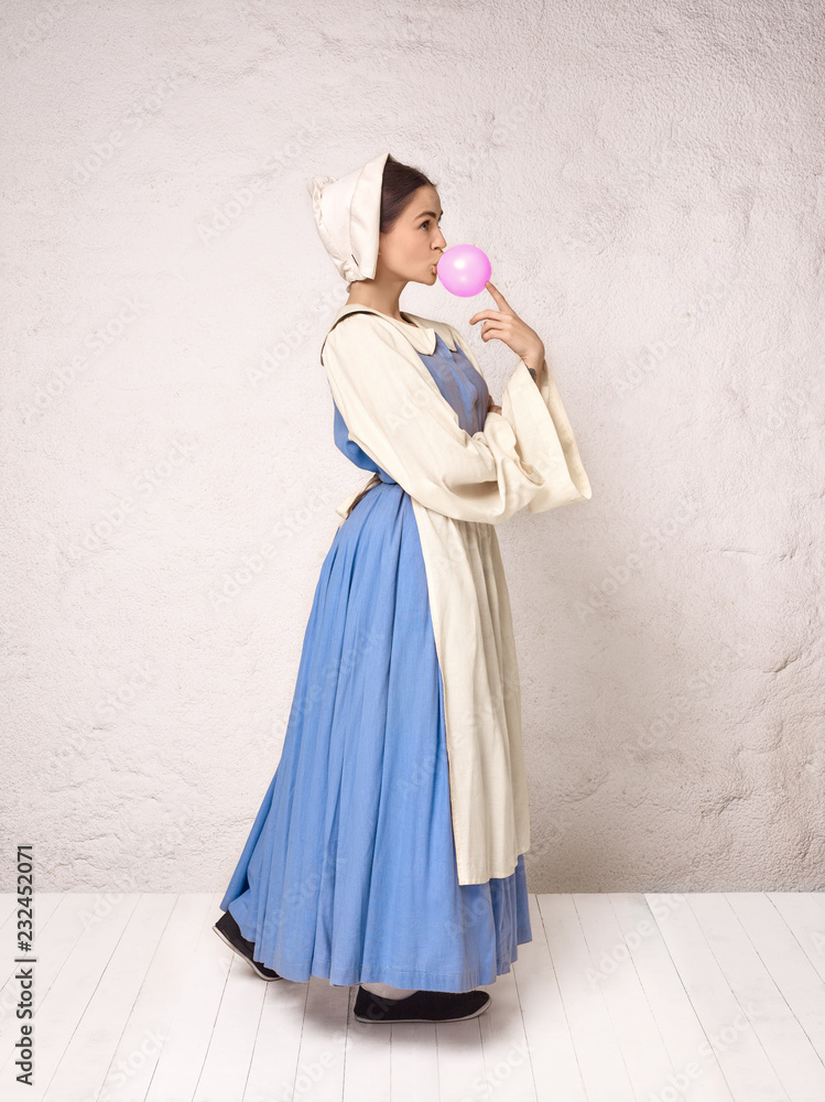 Fototapeta premium Medieval Woman in Historical Costume Wearing Corset Dress and Bonnet.