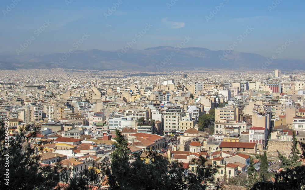 Athens from above with white buildings architecture, mountain, trees, blue sky in the morning hour in summer