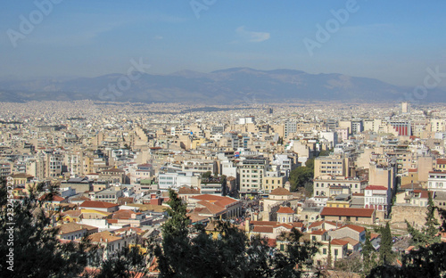 Athens from above with white buildings architecture, mountain, trees, blue sky in the morning hour in summer