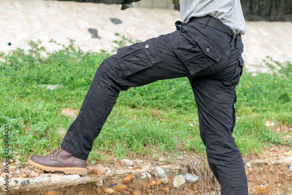 male tourist wearing cargo pants standing in the park. male tourist wearing cargo pants standing in the park.