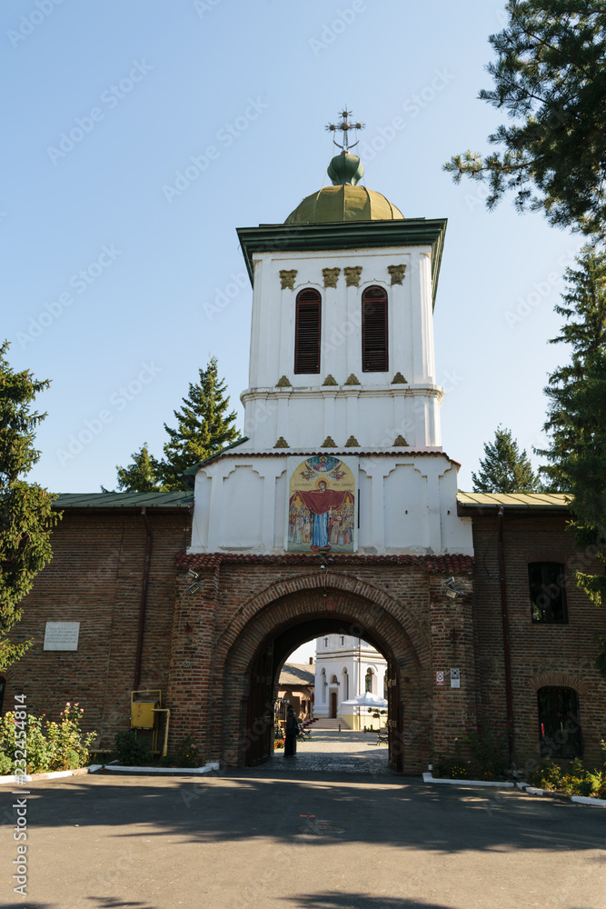 Bucharest, Romania - August 10, 2017: Tourist visiting Plumbuita monastery in Bucharest, Romania - entrance and bell tower