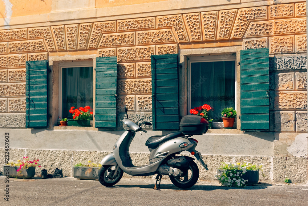 Beluno, Italy August 7, 2018: Perarollo di Cadore mountain village. moped is parked on the street.