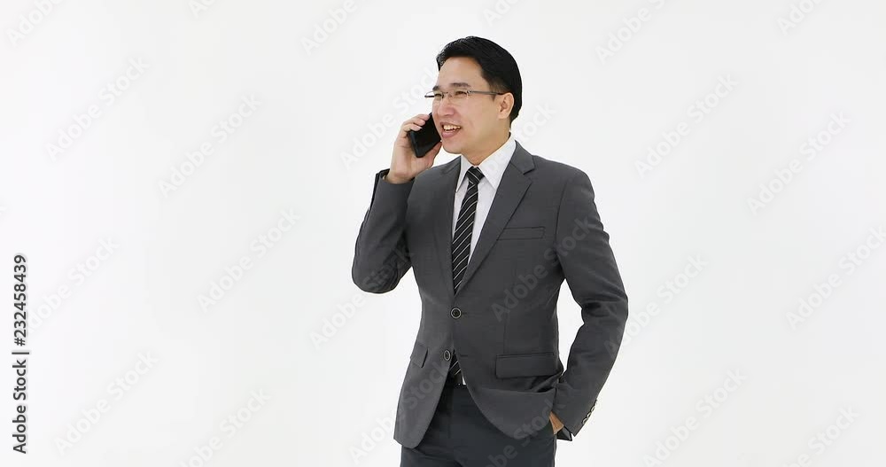 Asian business man in suit talking on mobile phone on white background. Asian business man in suit talking on mobile phone on white background.