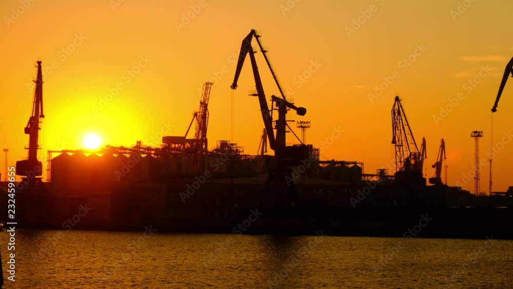 Beautiful sunsets in the sea trading port. Portal cranes in the seaport at sunset of the day. Beautiful sunsets in the sea trading port. Portal cranes in the seaport at sunset of the day.
