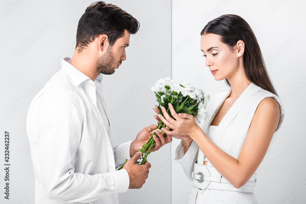 close up of adult woman gently holding bouquet with man close up of adult woman gently holding bouquet with man
