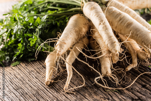 Close-up parsnip with parsley top on wooden board