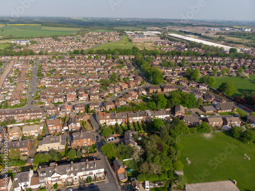 Typical UK Town aerial photo showing rows of houses, roads, parks and communal area