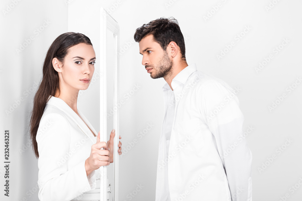 beautiful adult woman holding frame while handsome man looking on white background beautiful adult woman holding frame while handsome man looking on white background