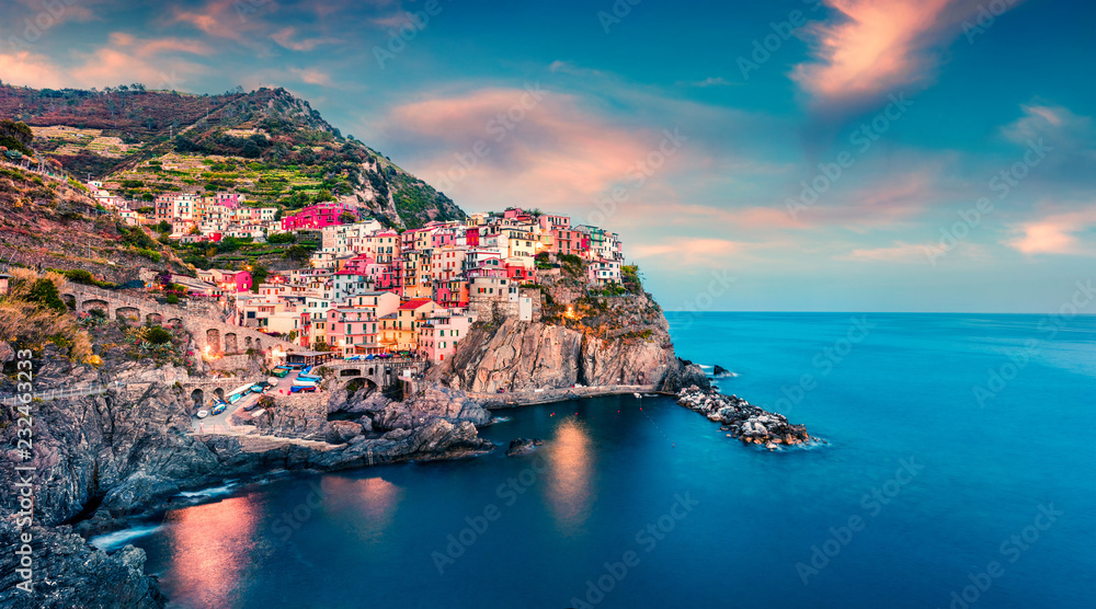 Second city of the Cique Terre sequence of hill cities - Manarola. Colorful spring sunset in Liguria, Italy, Europe. Picturesqie seascape of Mediterranean sea. Traveling concept background.