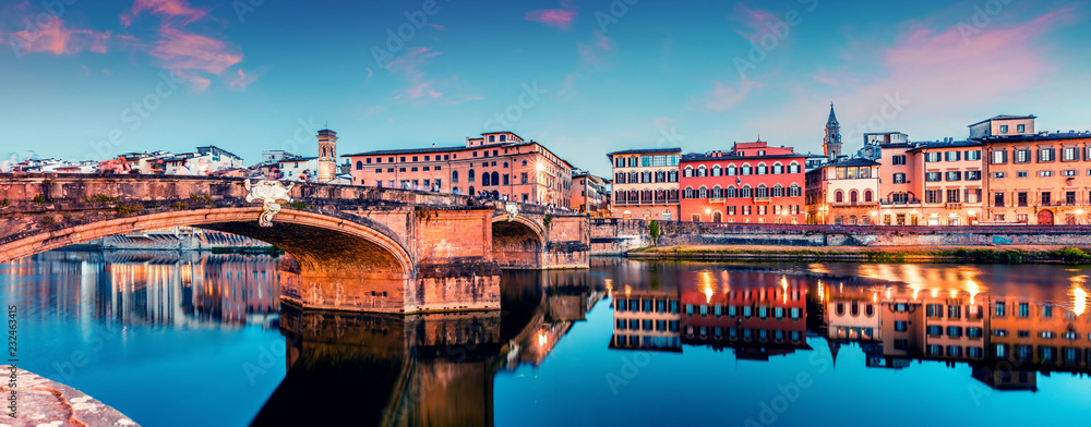Picturesque medieval arched St Trinity bridge (Ponte Santa Trinita) over Arno river. Colorful spring sunset in Florence, Italy, Europe. Traveling concept background. - obrazy, fototapety, plakaty 