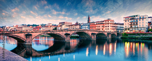 Picturesque medieval arched Ponte alla Carraia bridge over Arno river. Colorful spring sunset in Florence, Italy, Europe. Traveling concept background.
