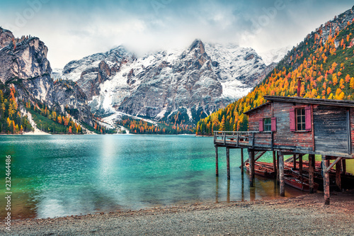 Boat hut on Braies Lake with Seekofel mount on background. Colorful autumn landscape in Italian Alps, Naturpark Fanes-Sennes-Prags, Dolomite, Italy, Europe. Traveling concept background. photo