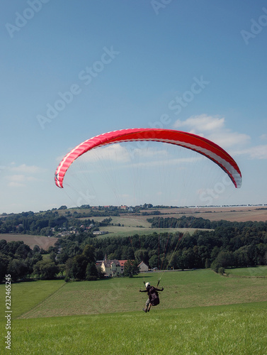 Foto mann steht am hang mit gleitschirm und fliegt hang entlang thermik