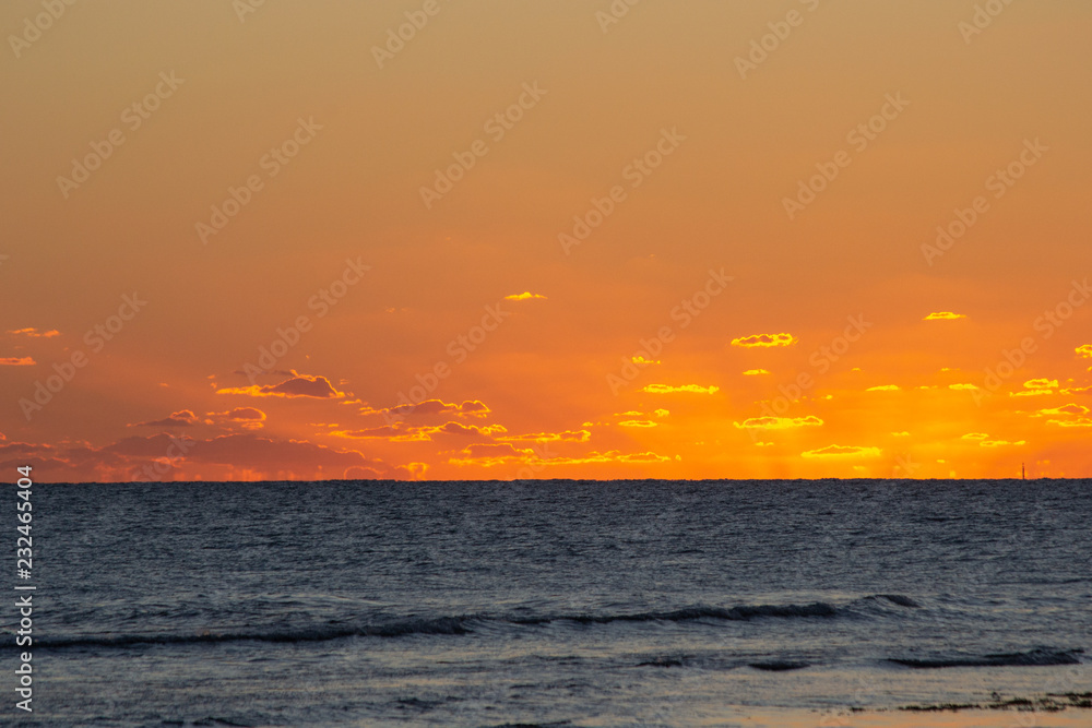 Obraz premium Sunset at the beach with orange colors