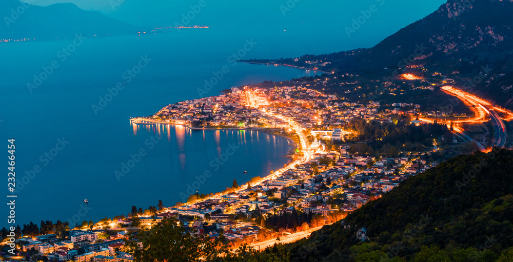 Fototapeta premium View from the bird's-eye of Kamena Vourla town in the evening light. Colorful spring cityscape in Greece, Europe. Beautiful sunset on Aegean Sea. Traveling concept background.