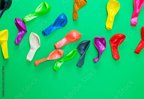 colorful deflated balloons on a green background