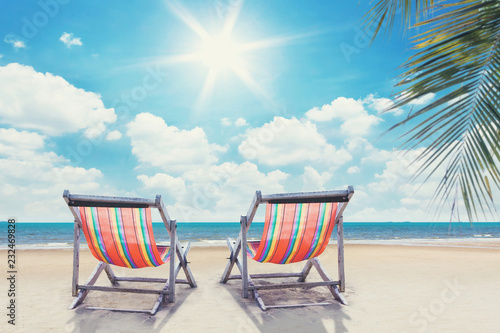 two beach chairs on palmbeach with sunny sky photo