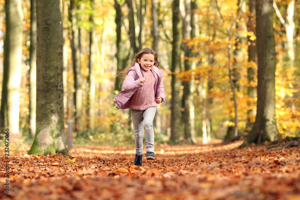 Kleines Mädchen rennt durch einen herbstlichen Wald Kleines Mädchen rennt durch einen herbstlichen Wald
