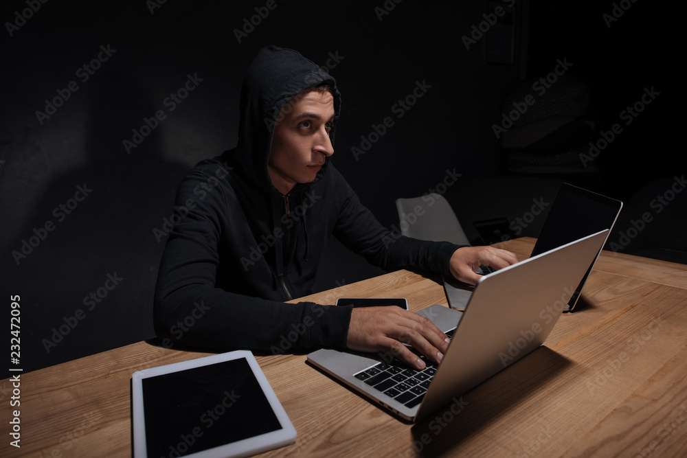 hacker in black hoodie using laptops in dark room, cyber security concept hacker in black hoodie using laptops in dark room, cyber security concept